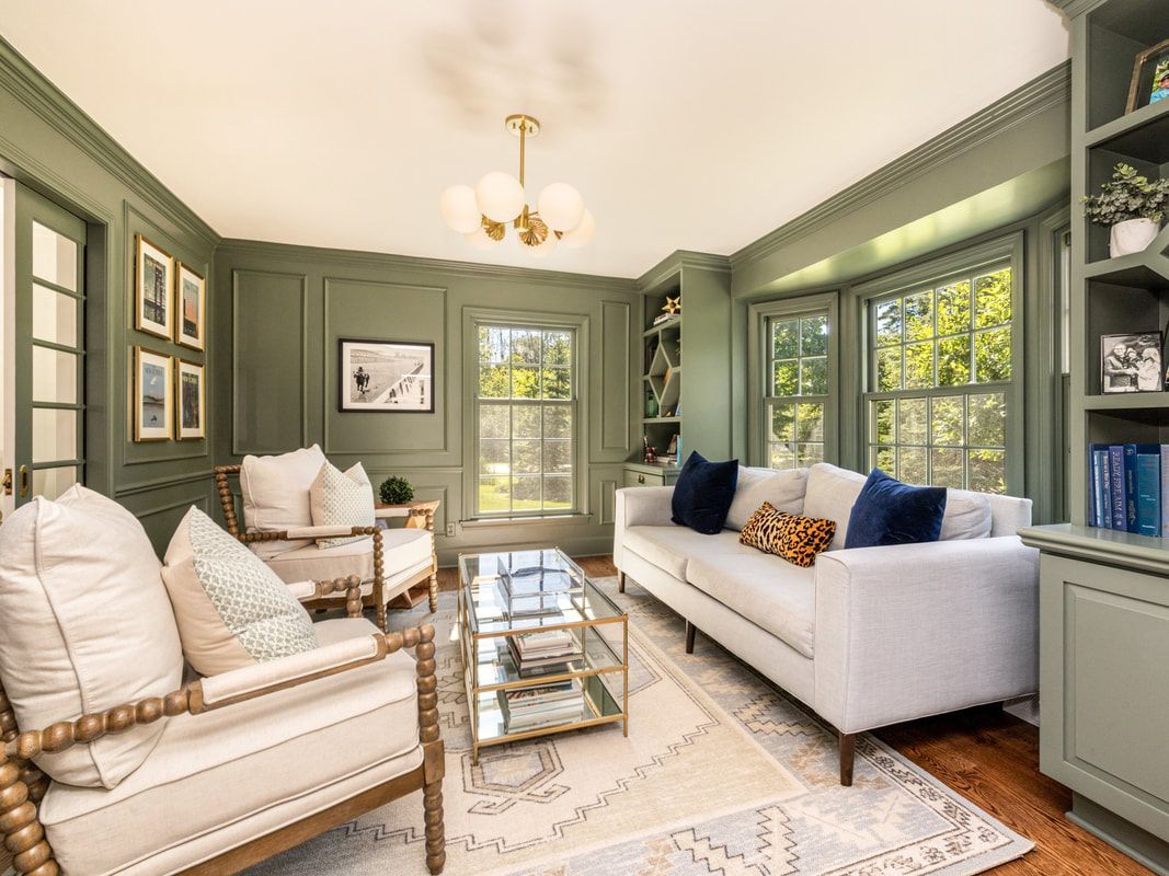 A living room with a couch , chairs , and a coffee table.