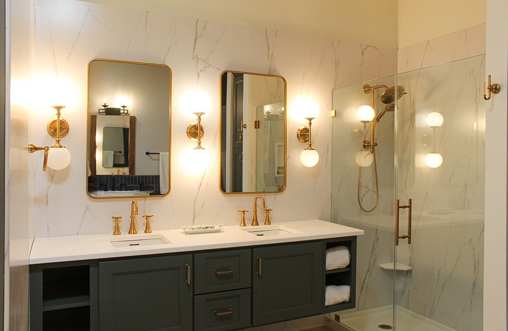 A bathroom with two sinks , two mirrors and a walk in shower.