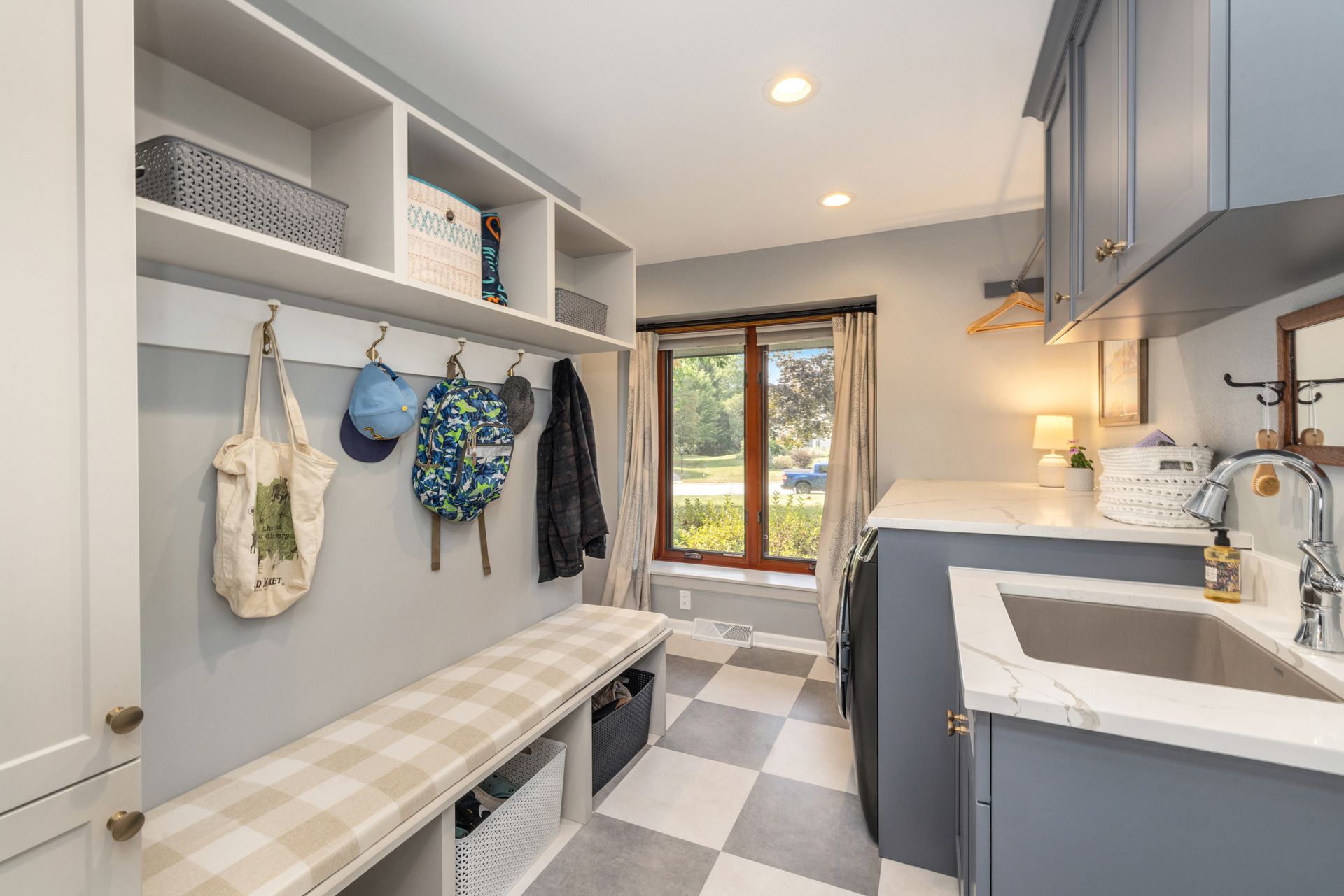 A laundry room with a bench and a sink.