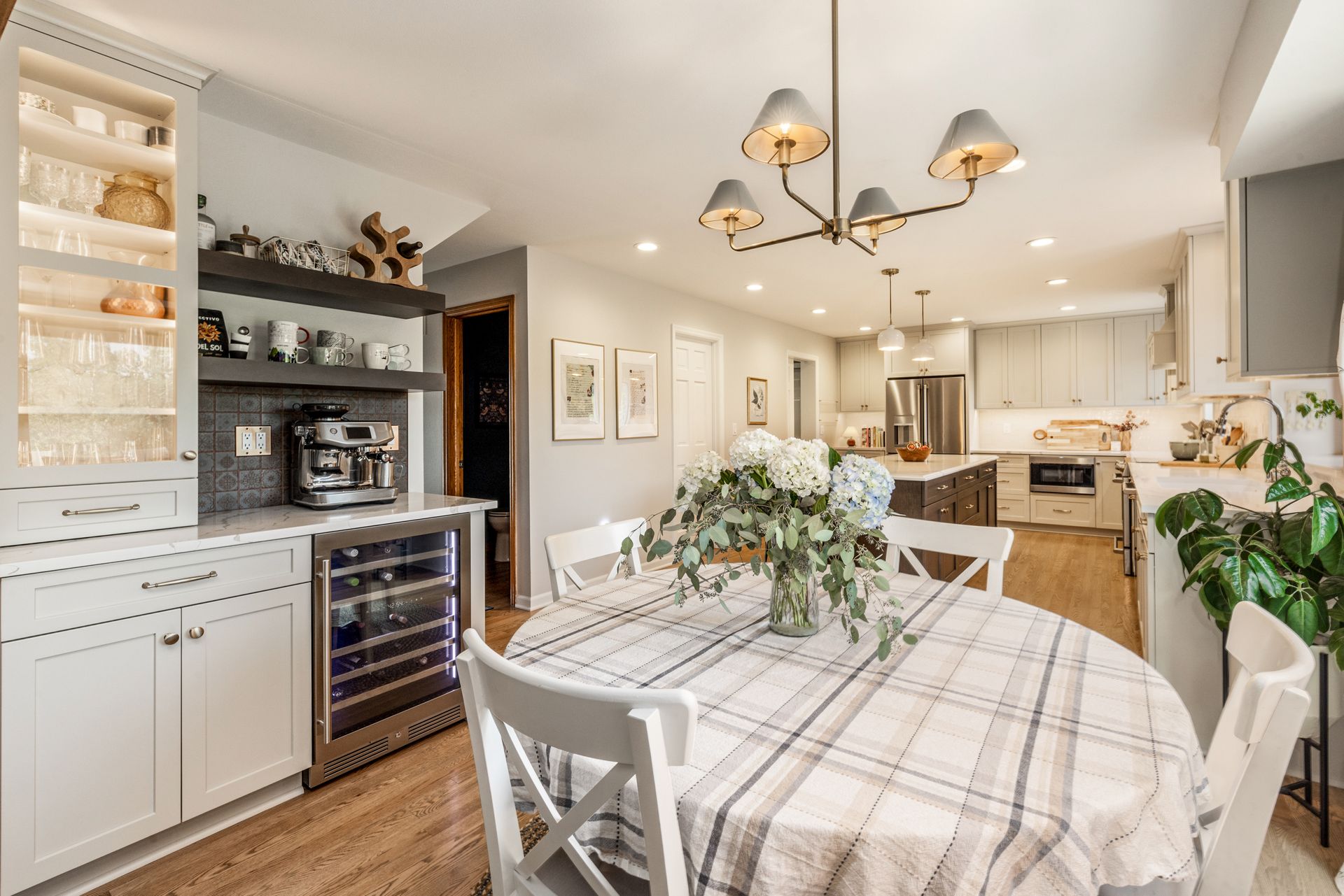 A kitchen with a table and chairs and a wine cooler.