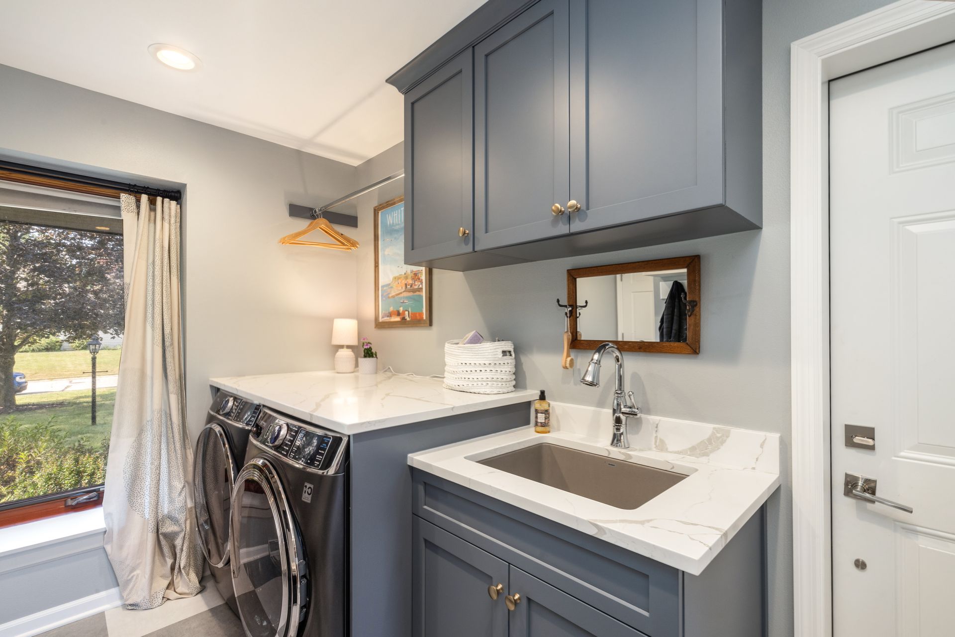 A laundry room with a washer and dryer and a sink.