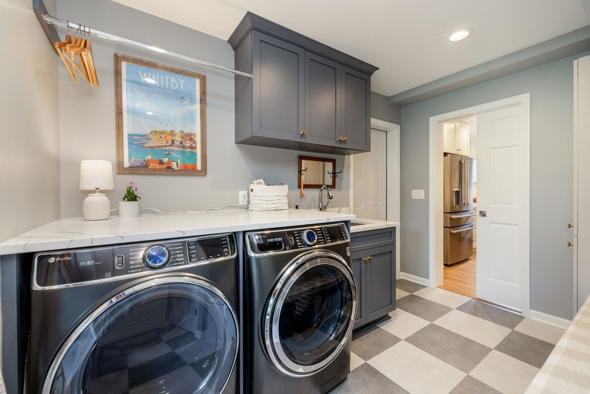A laundry room with a washer and dryer and a checkered floor.