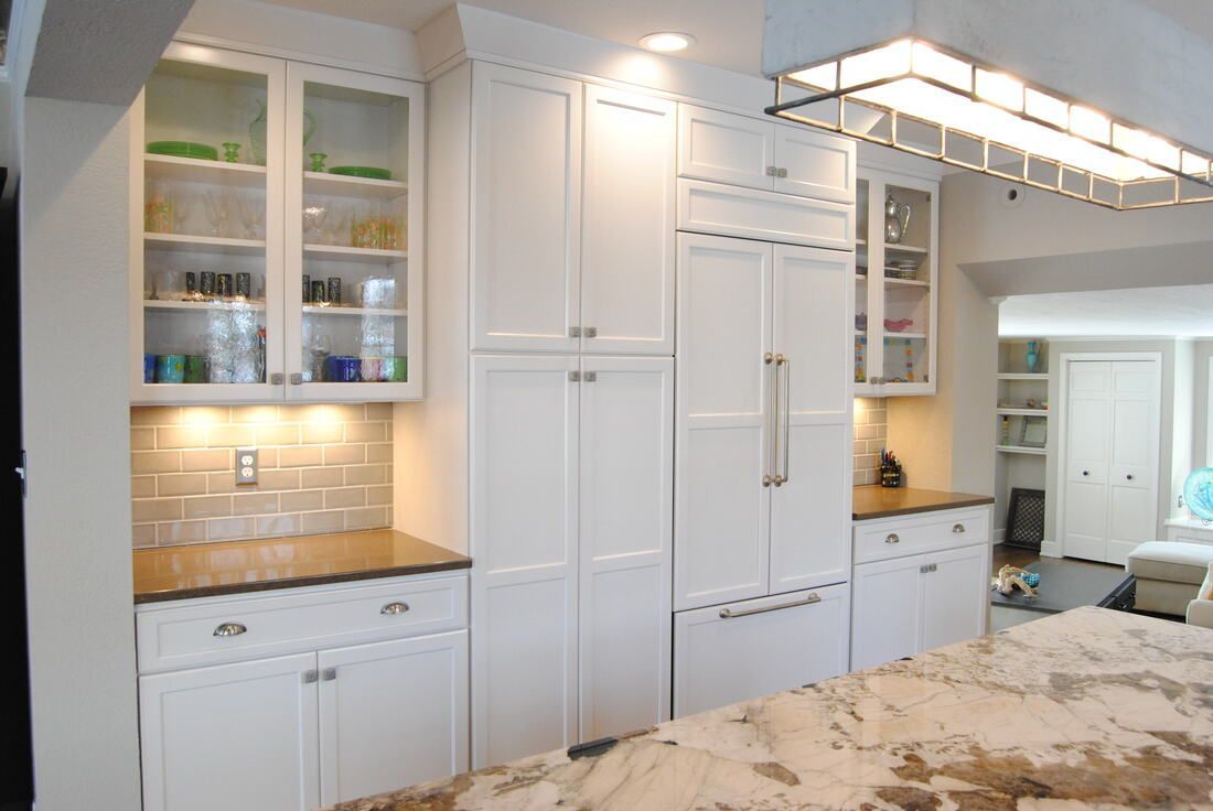 A kitchen with white cabinets and granite counter tops