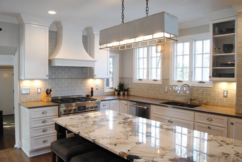 A kitchen with white cabinets and granite counter tops