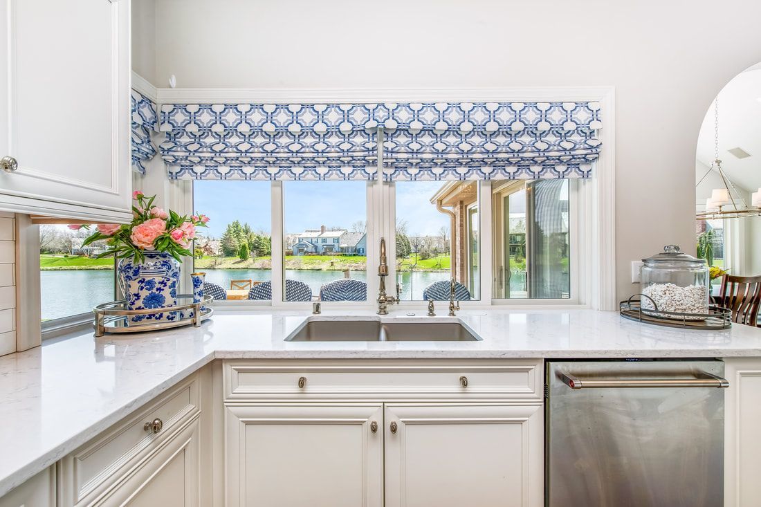 A kitchen with a sink and a window overlooking a lake.
