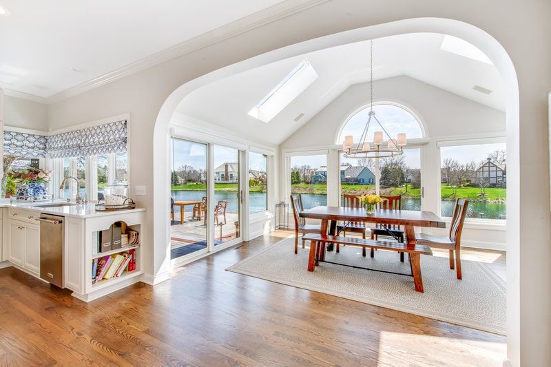 A dining room with a table and chairs and a large window.