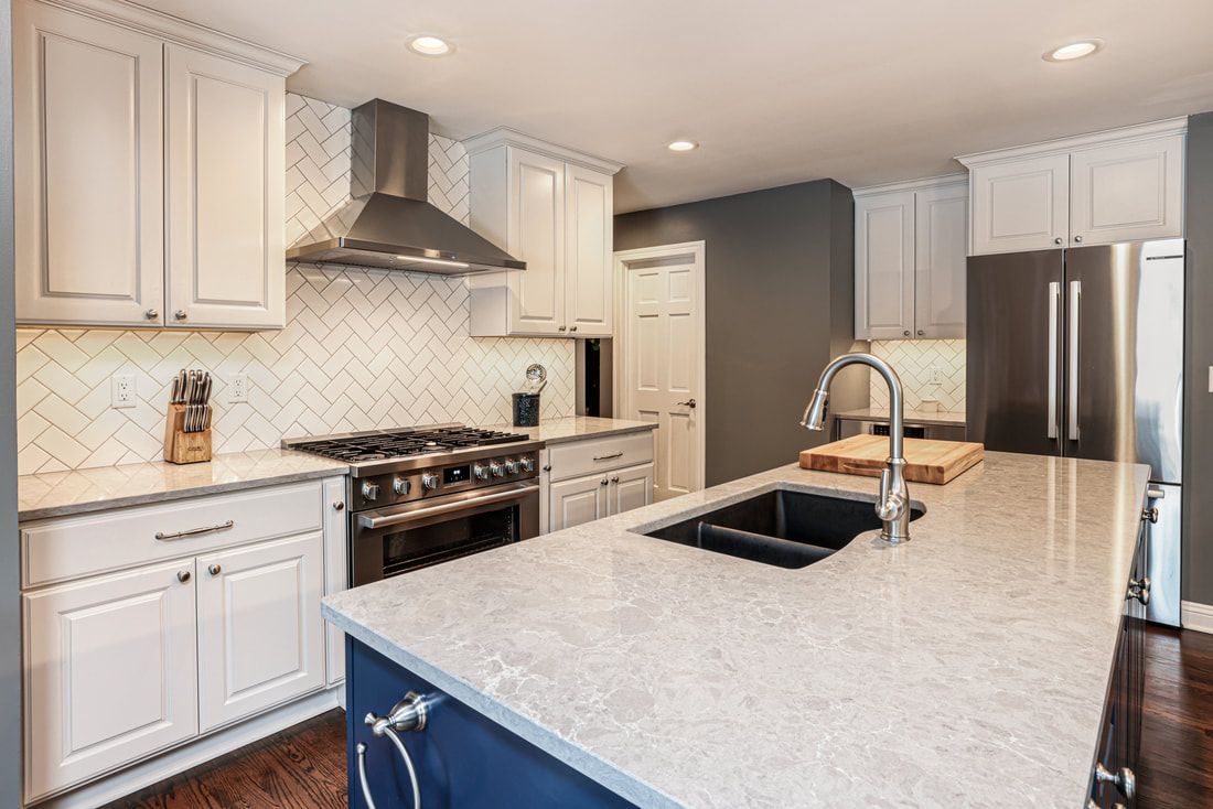 A kitchen with white cabinets , stainless steel appliances , a sink , and a stove.