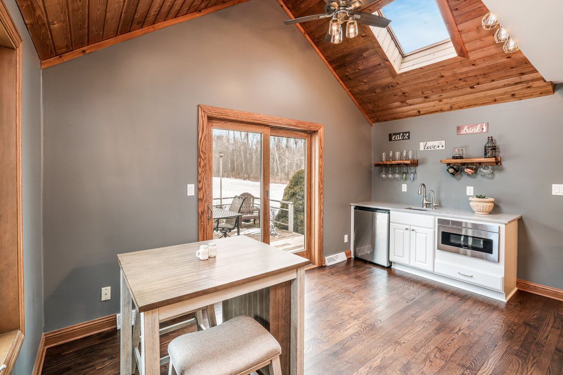 A kitchen with a table and chairs and a skylight in the ceiling.