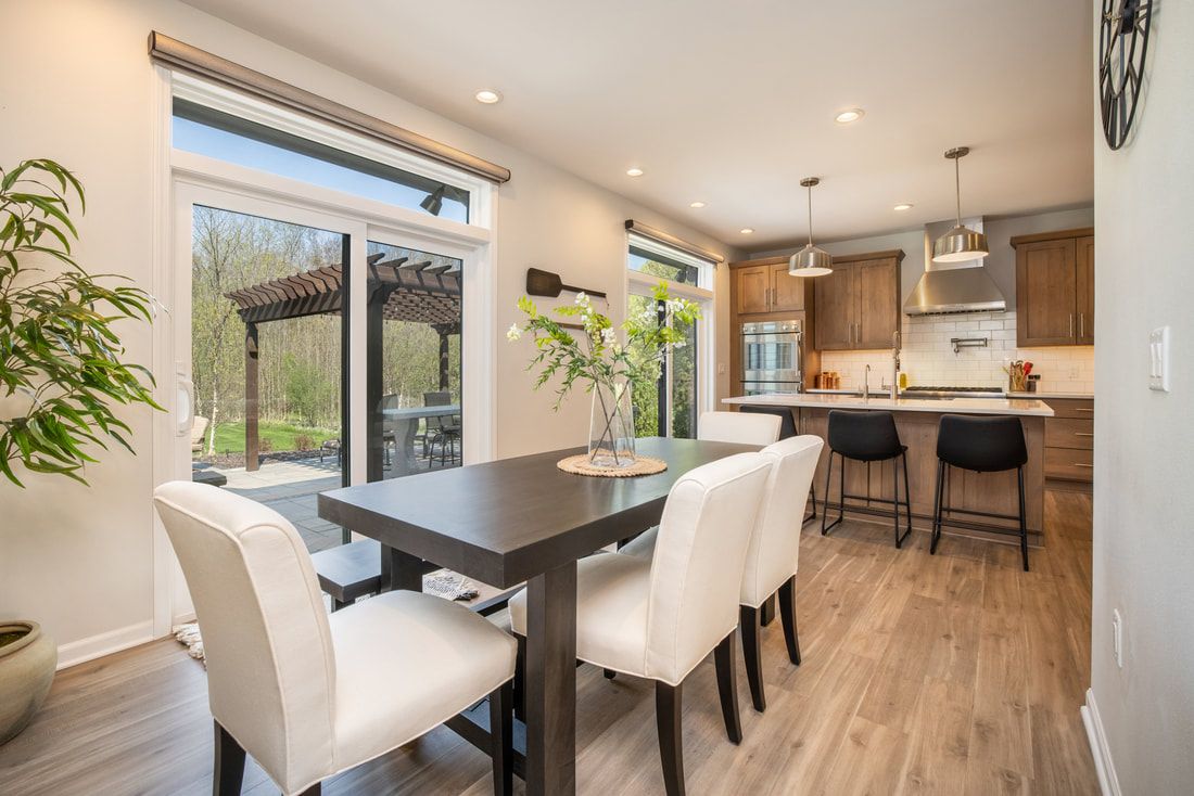 A dining room with a table and chairs and a kitchen.