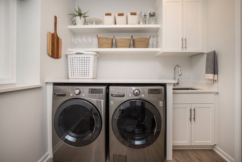 A laundry room with a washer and dryer and a sink.