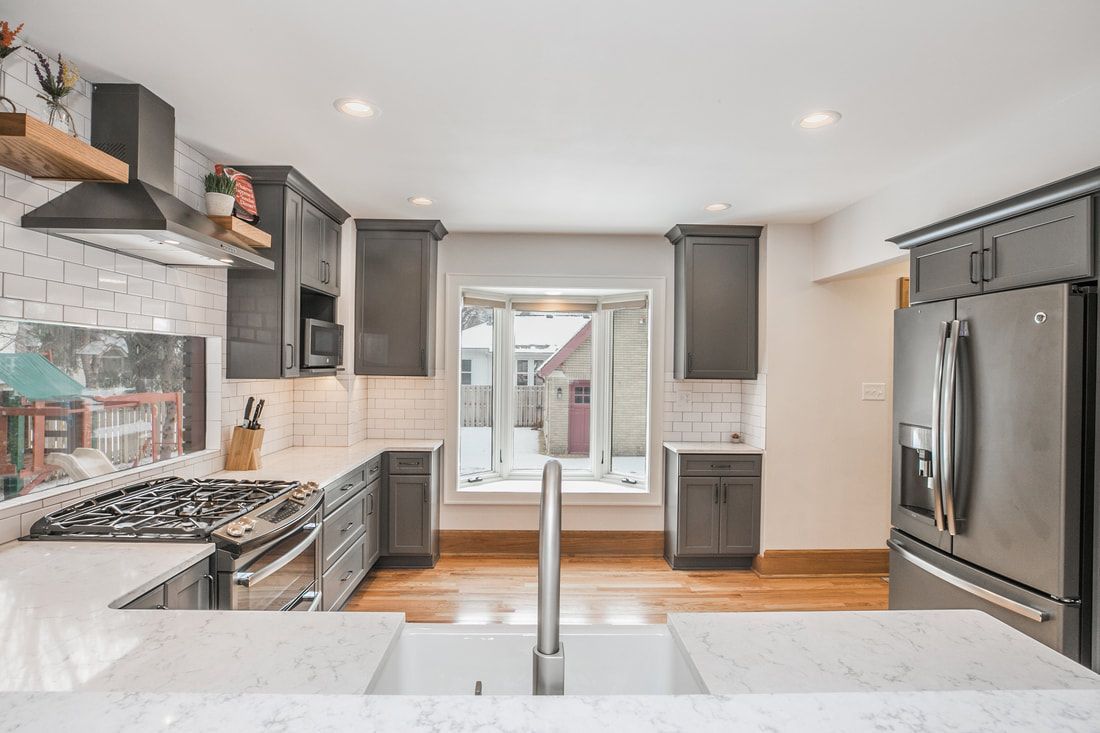 A kitchen with a stove , refrigerator , sink and a window.