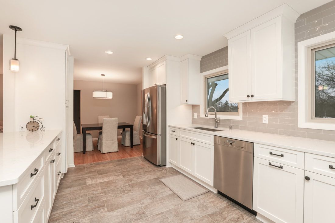 A kitchen with white cabinets and stainless steel appliances.