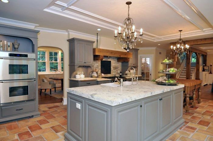A kitchen with a large island and a chandelier hanging from the ceiling.