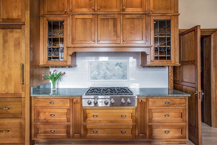 A kitchen with wooden cabinets and a stove top oven.