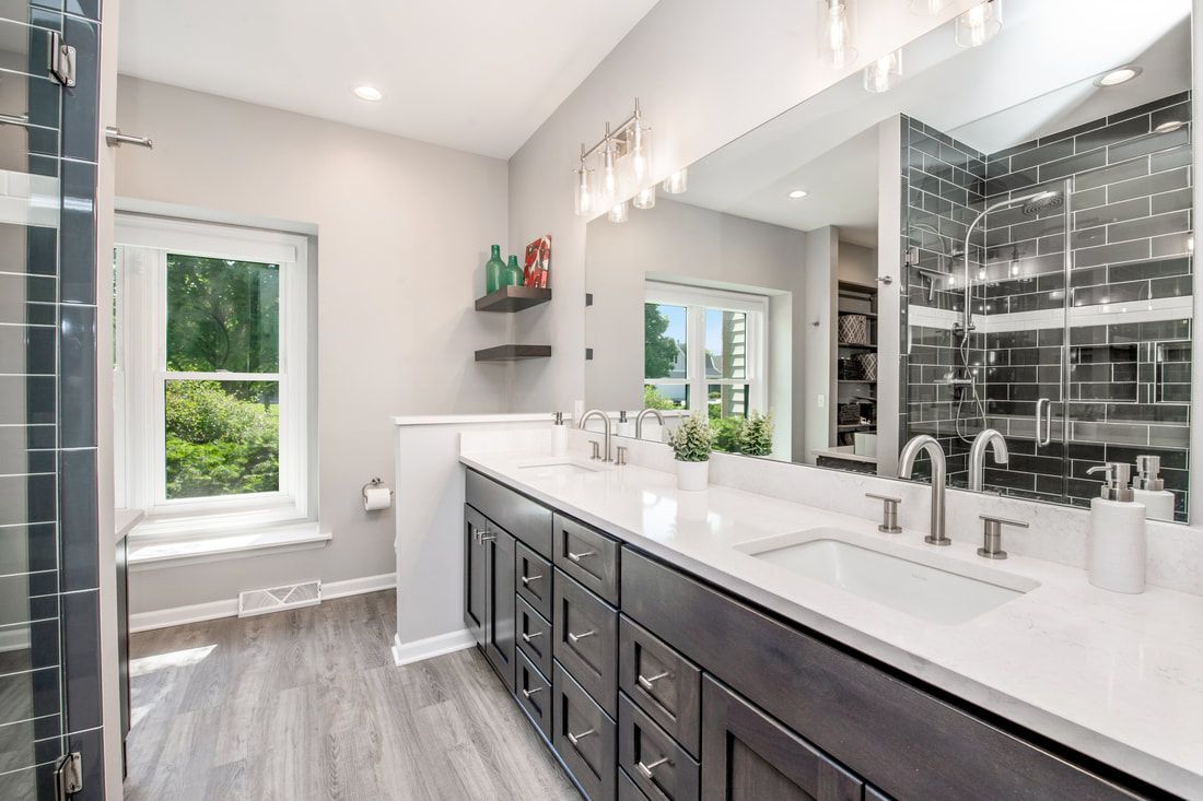 A bathroom with two sinks and a large mirror.