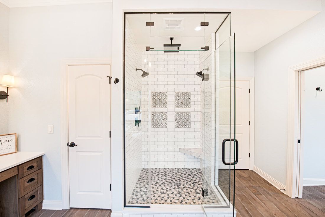 A bathroom with a walk in shower with a glass door.