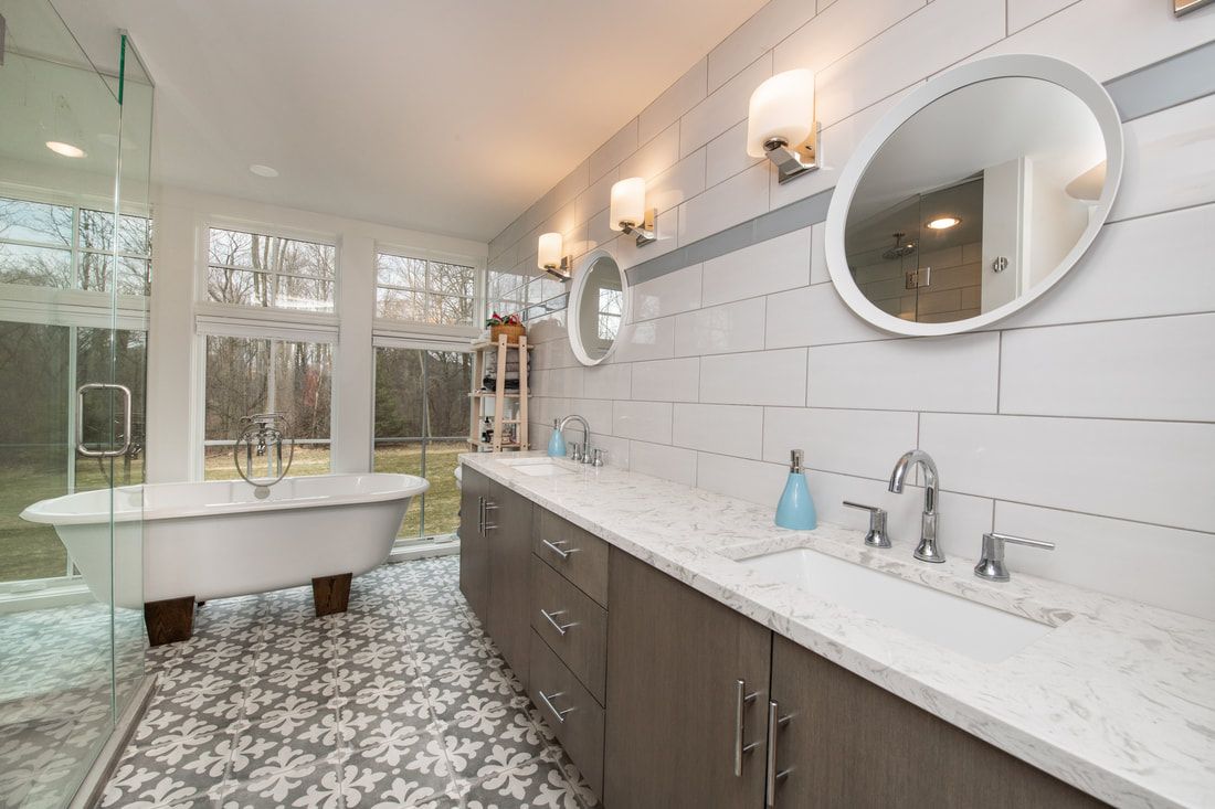 A bathroom with a tub , sink , and mirror.