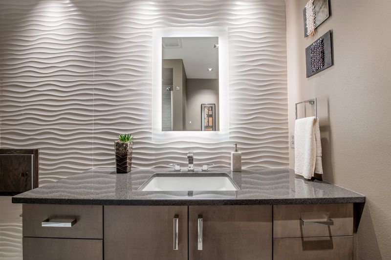 A bathroom with a sink , mirror and cabinets.