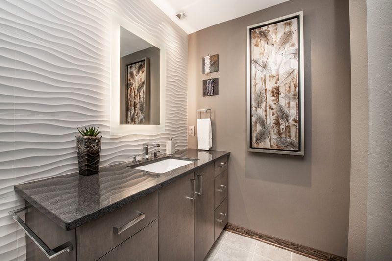 A bathroom with a sink , mirror and painting on the wall.