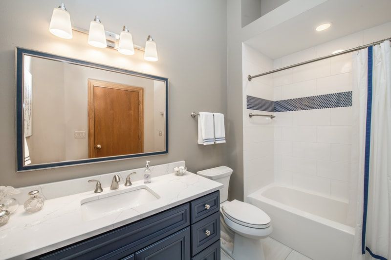 A bathroom with a sink , toilet , tub and mirror.