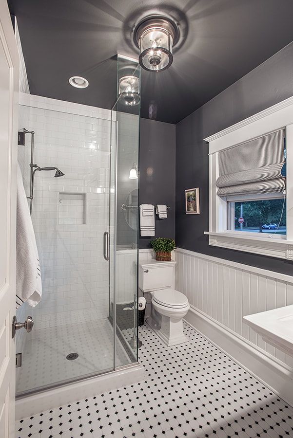 A bathroom with a toilet , shower , and window.