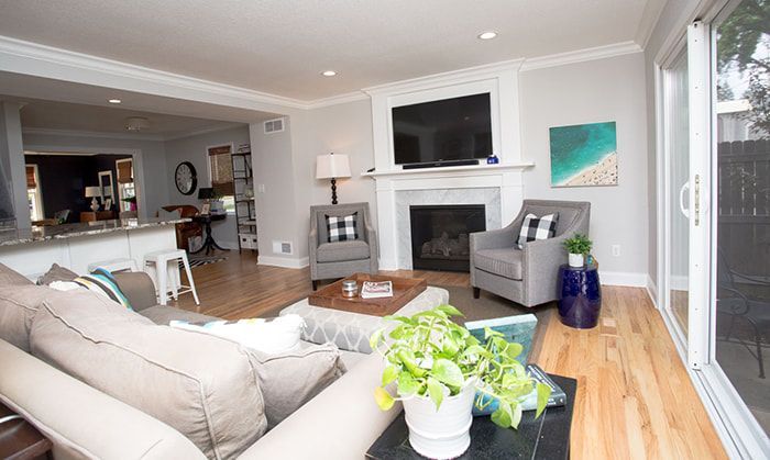 A living room with a couch , chairs , a fireplace and a flat screen tv.