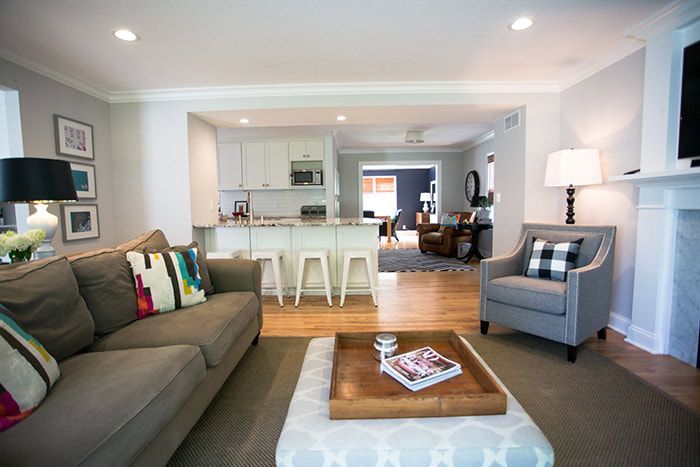 A living room with a couch , chair , coffee table and fireplace.