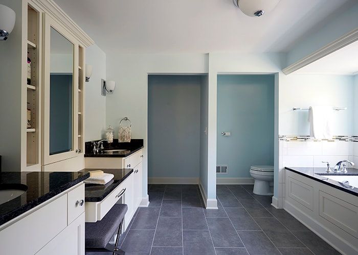 A bathroom with two sinks a toilet and a bathtub