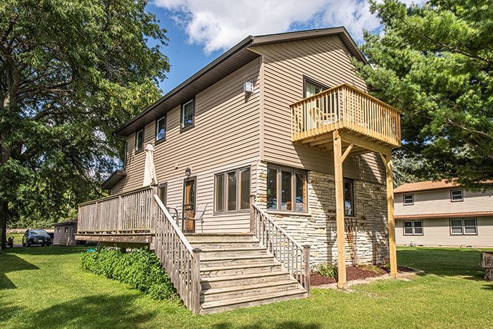 A house with a large deck and stairs leading up to it.