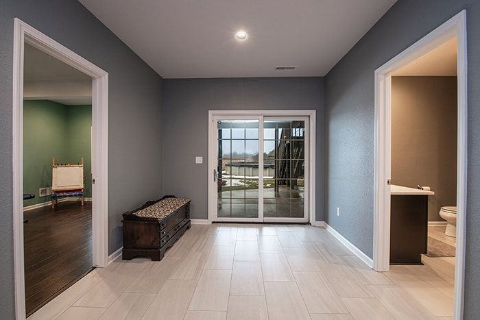 An empty room with a sliding glass door and a bench.