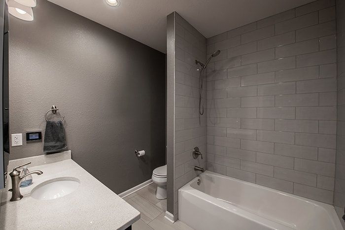 A bathroom with a sink , tub , toilet and shower.