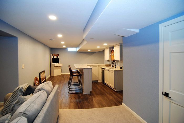A living room with a couch and a kitchen in the background.