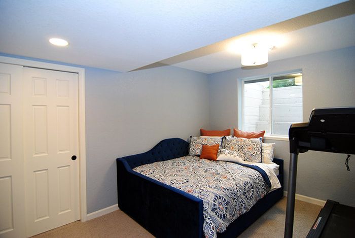 A bedroom with a bed and a treadmill in it