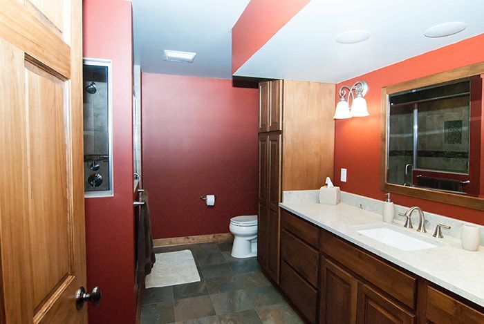 A bathroom with a toilet , sink and mirror