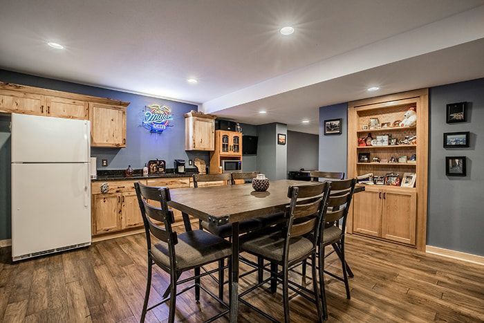 A basement with a dining table and chairs and a kitchen.
