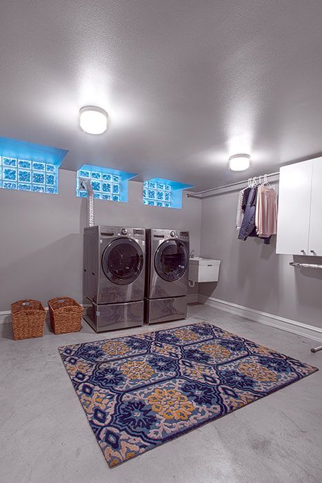 A laundry room with a washer and dryer and a rug.