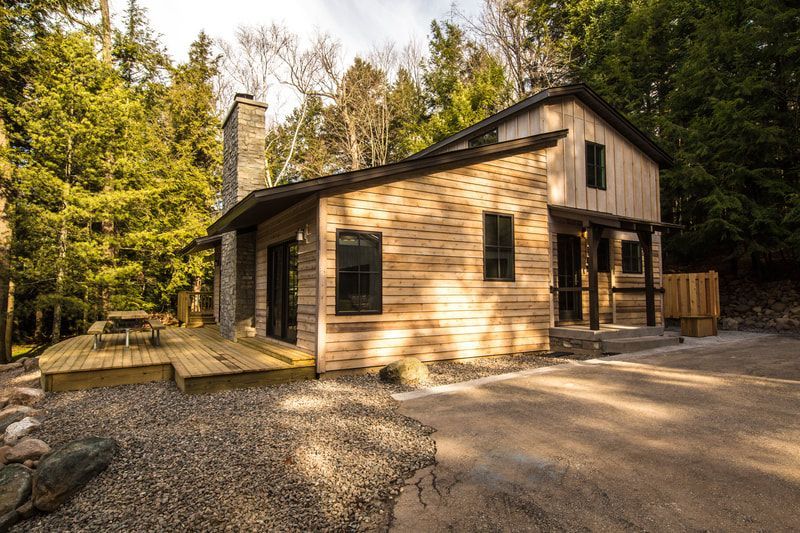 A small wooden house is sitting in the middle of a forest.