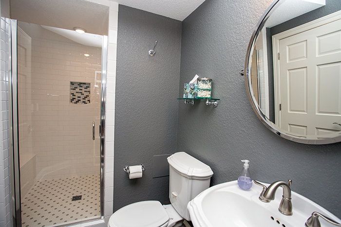 A bathroom with a toilet , sink and shower.