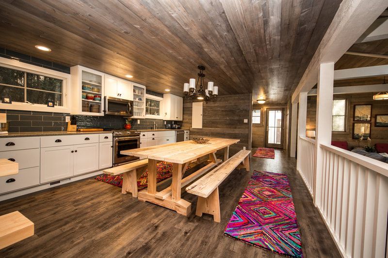 A kitchen with a long wooden table and benches.