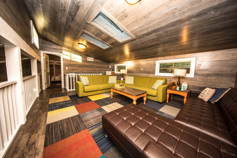 A living room with two couches , a coffee table , and a rug.