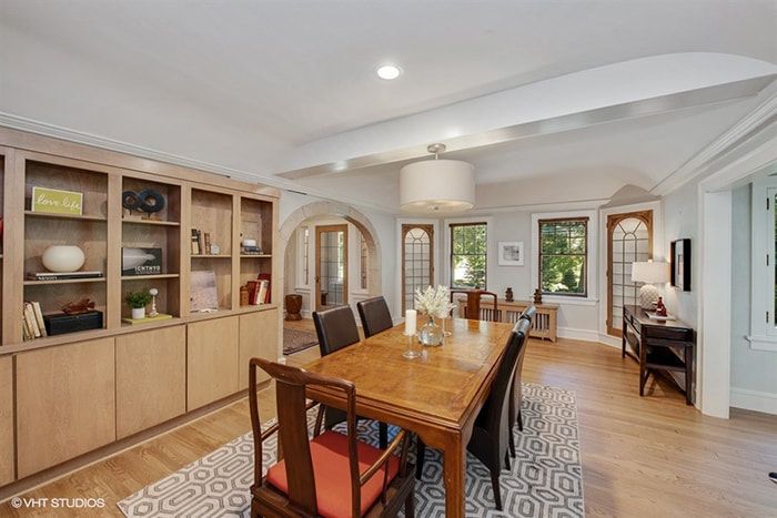 A dining room with a long wooden table and chairs.