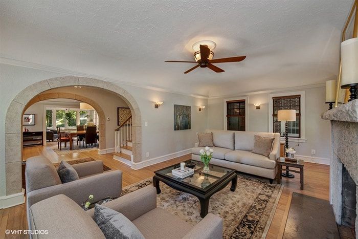 A living room with a couch , chairs , coffee table and fireplace.