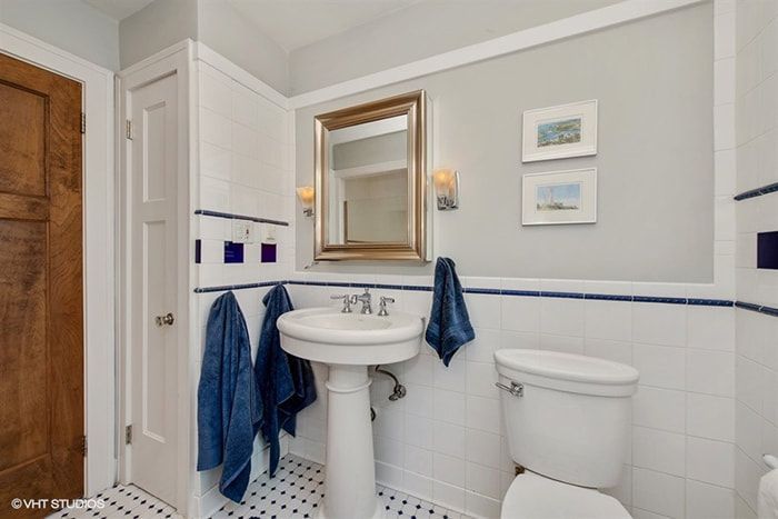 A bathroom with a toilet a sink and a mirror