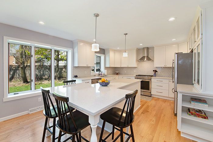 There is a large island in the middle of the kitchen with a table and chairs.