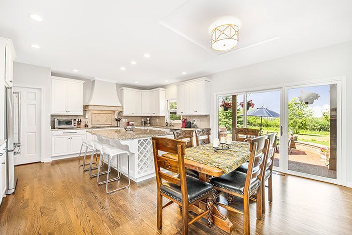 A kitchen and dining room in a house with a table and chairs.