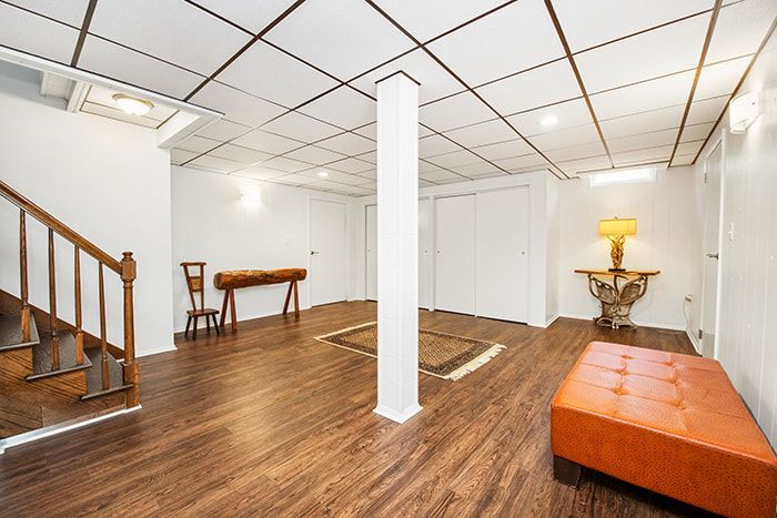 A basement with hardwood floors and a staircase.