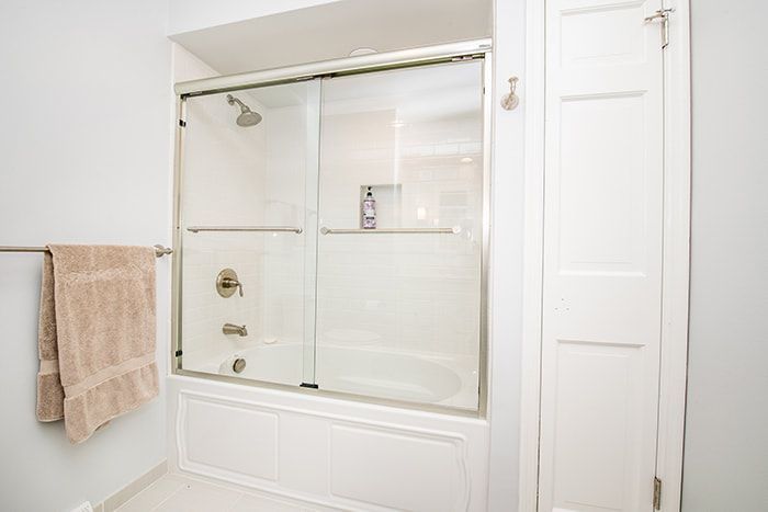 A bathroom with a sliding glass shower door and a bathtub.