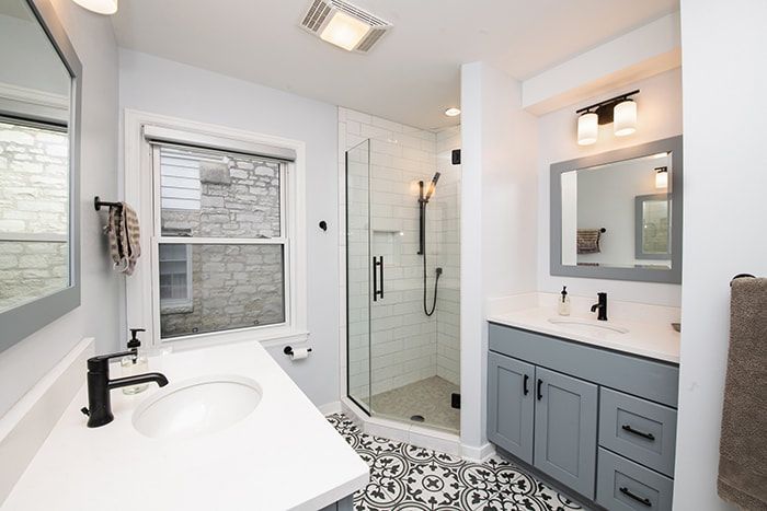 A bathroom with a sink , mirror , and walk in shower.