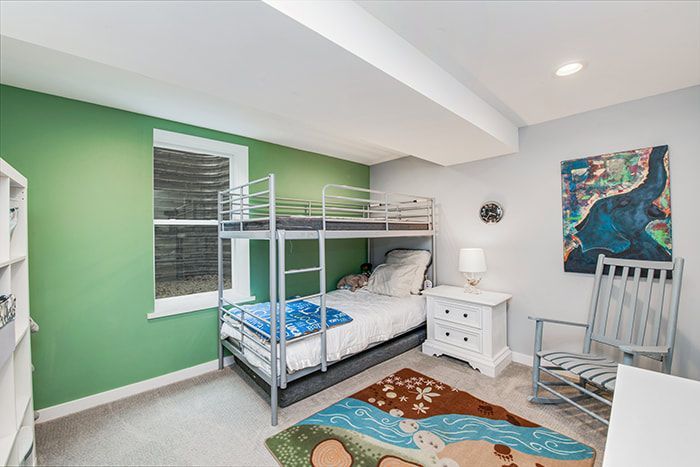 A bedroom with a bunk bed and a rocking chair.