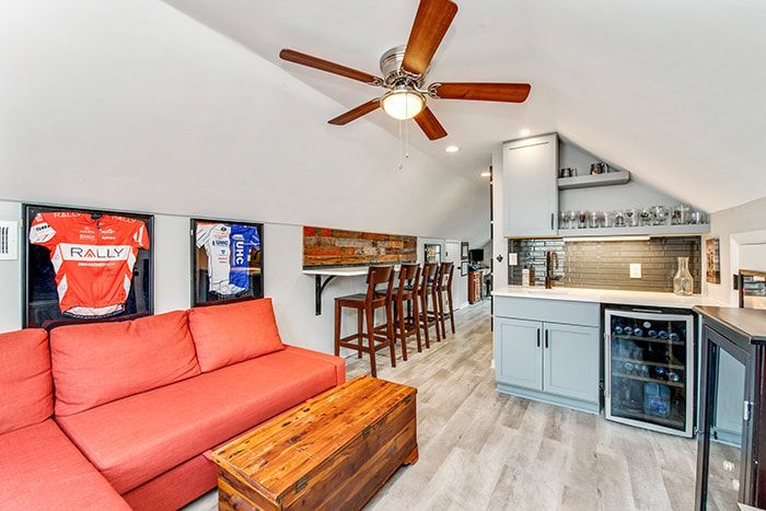A living room with a red sectional couch and a ceiling fan.